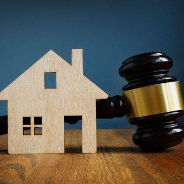 A wooden house next to a gavel