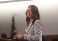 A woman stands at a podium.