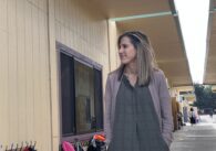 A woman standing outside a classroom.