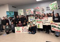 Students stand with protest signs
