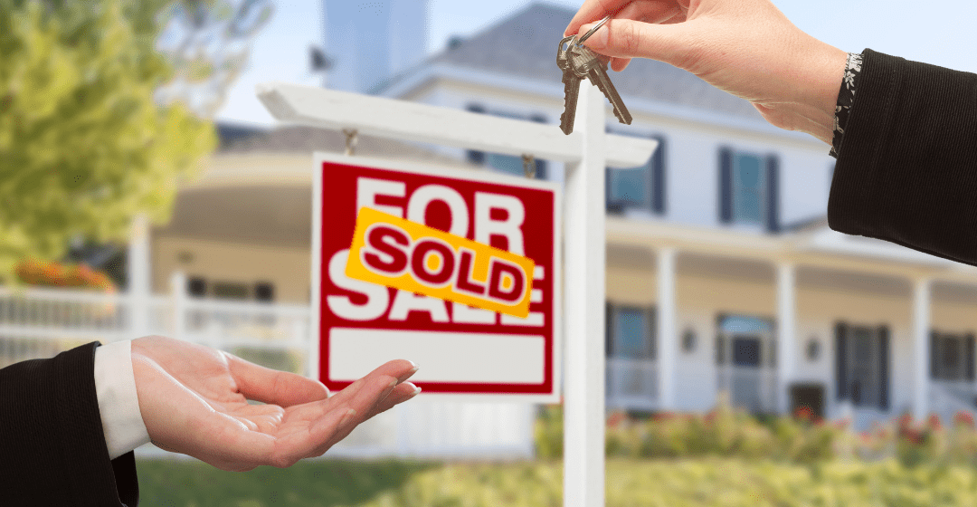 A for sale sign in front of a house that has been sold