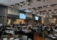 A convention room full of people at round tables