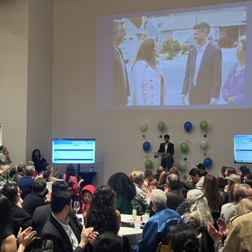 A crowd looks at a man standing at a podium