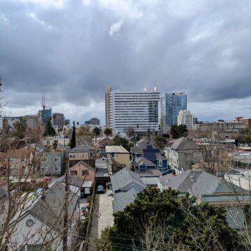 A view of San Jose with houses in the foreground and City Hall in the background