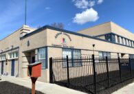 Exterior of African American Community Service Agency, beige two floor building with blue trims and black fence