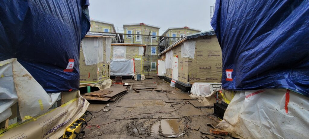 Modular homes under construction in San Jose covered in tarps to eliminate mold.
