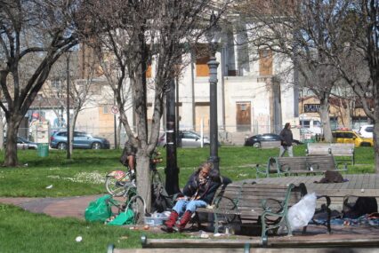 A homeless person sitting on a park bench in San Jose, California