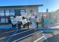 Middle school students hold protest signs outside their campus