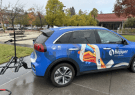 Blue minivan with Silicon Valley Hopper decal and a bike rack on the back