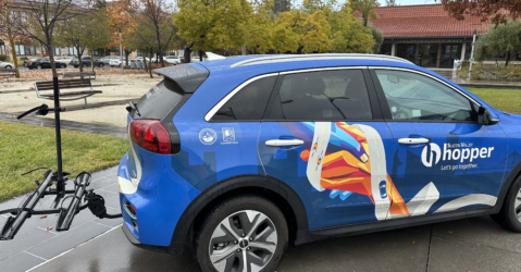 Blue minivan with Silicon Valley Hopper decal and a bike rack on the back