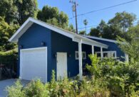 A blue ADU in San Jose surrounded by green bushes. Courtesy of Acton ADU