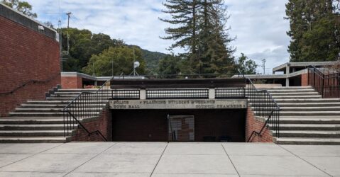Una foto de la entrada al Ayuntamiento de Los Gatos, con escaleras que conducen a la Sala del Consejo y al Departamento de Planificación, Construcción y Finanzas, y escaleras que conducen al Departamento de Policía y al Ayuntamiento.