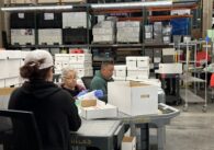 Election workers look through boxes of ballots at the Santa Clara County Registrar of Voters during a recount effort