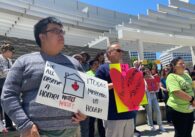 Protesters stand with signs outside San Jose City Hall
