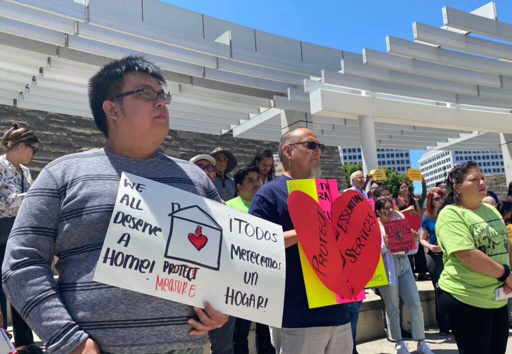 Protesters stand with signs outside San Jose City Hall