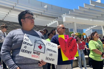 Protesters stand with signs outside San Jose City Hall