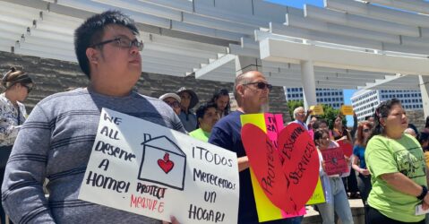 Protesters stand with signs outside San Jose City Hall