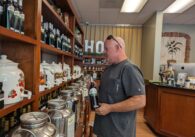 Shop owner looking at a shelf of merchandise.