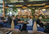 The interior of Doppio Zero, with people sitting at booths and a bar in the background