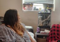 A woman in a wheelchair looks out a window