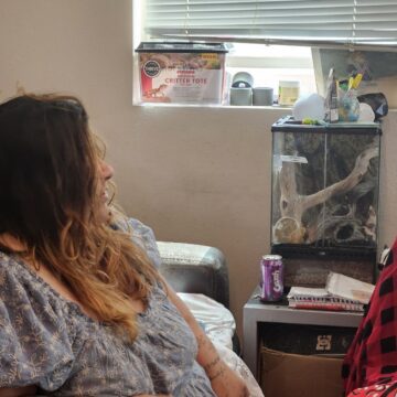 A woman in a wheelchair looks out a window