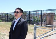 Man in black suit standing in front of the Vietnamese Heritage Community Garden