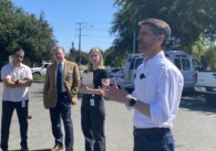 People stand outside in a semicircle