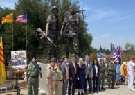 A line of people stand in front of a Vietnam War monument