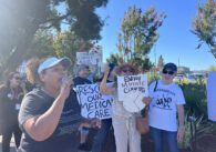 A crowd of people with protest signs outside a hospital in San Jose
