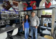 Two people stand inside a restaurant