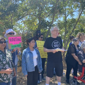 People stand in a line with protest signs
