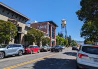 Campbell's small downtown, with cars driving down the street next to a Greek restaurant and its iconic water tower.