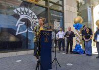 Woman stands behind podium labelled with SJSU