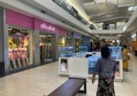 A kiosk and retail store inside a shopping mall