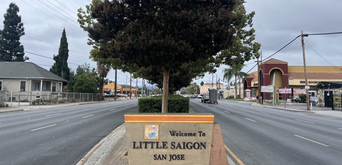 A neighborhood sign in the median of a street with a tree behind it in San Jose, California