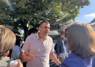 A politician stands talking to supporters