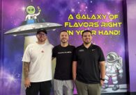 Three men stand inside an ice cream shop