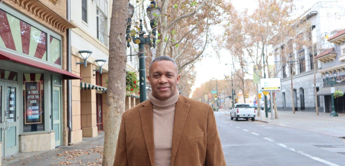 A man in a turtleneck and blazer waking outside in San Jose, California