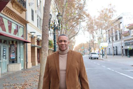 A man in a turtleneck and blazer waking outside in San Jose, California