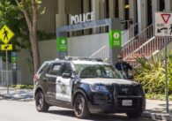 A police cruiser and officer outside the station