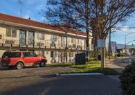 The outside of a Motel 6, with room doors and the parking lot.