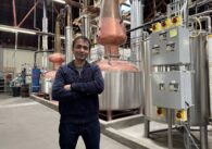 A man stands inside a whiskey distillery