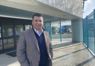A man standing outside the entrance of a building