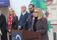 A woman speaks into a microphone at a podium