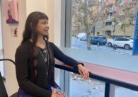 A woman sitting at a counter looking out a window