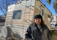 A man standing outside in front of an RV