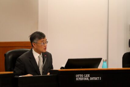 Otto Lee, District 3 Supervisor, speaking from board dias. Man with square glasses and short black-grey hair wearing a suit with a striped tie.