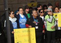 People stand with protest signs