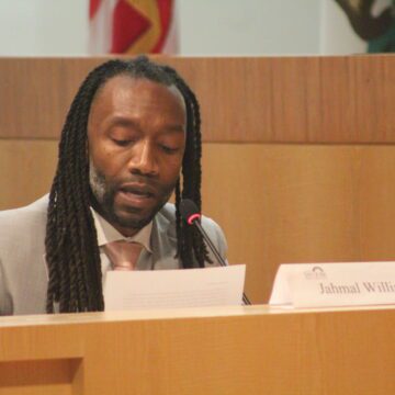 Jahmal Williams tại phòng họp của Hội đồng thành phố San Jose vào ngày 28 tháng 1 năm 2025. Ảnh của Vicente Vera. Một người đàn ông da đen đang ngồi trong một cuộc họp của chính phủ ở San Jose, California