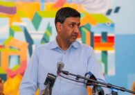 A man stands at a podium with microphones on it